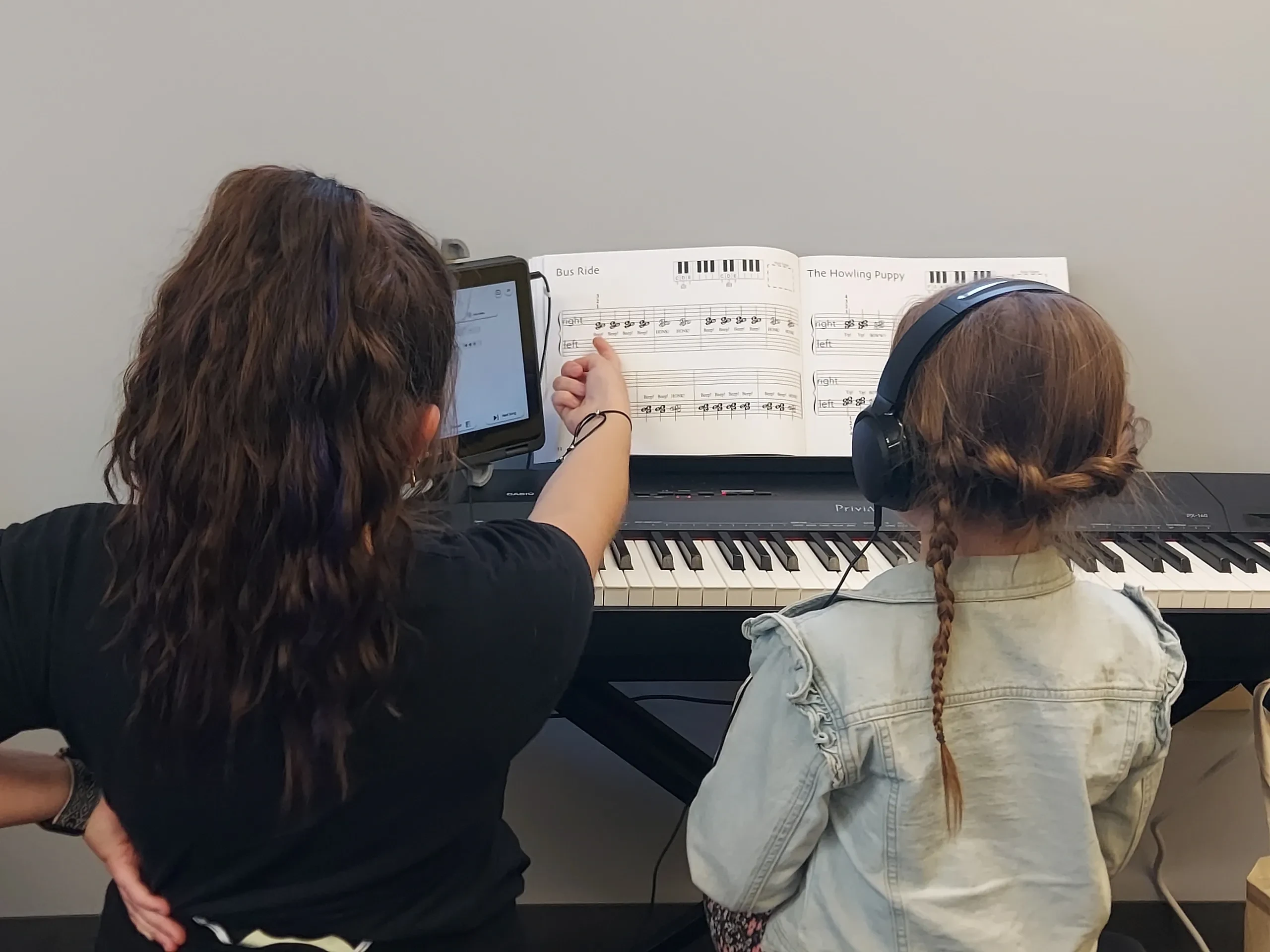 Students learning piano with sheet music