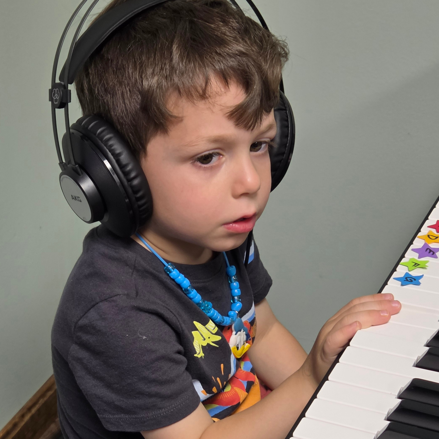 Young child focused at piano keyboard