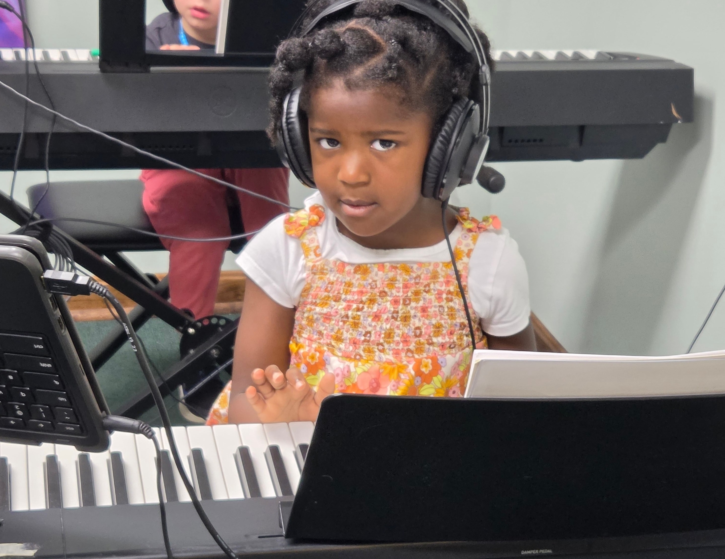Young boy playing piano keyboard in music class